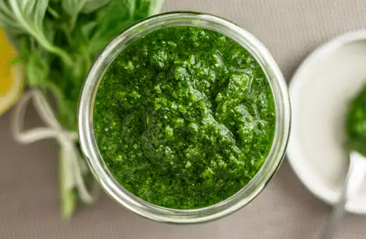 pesto is a traditional italian sauce made from crushed garlic olive oil parmesan cheese pine nuts and basil leaves